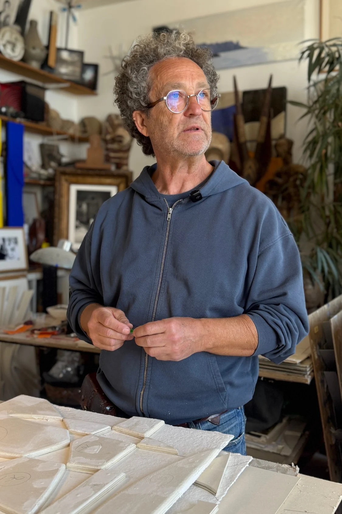 René Galassi dans son atelier, devant un relief blanc posé sur la table
